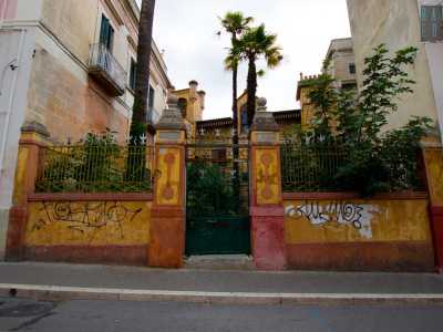 Ed eccoci di fronte all�edificio. Si nota subito il suo stato di lungo abbandono, con il muro imbrattato da scritte...